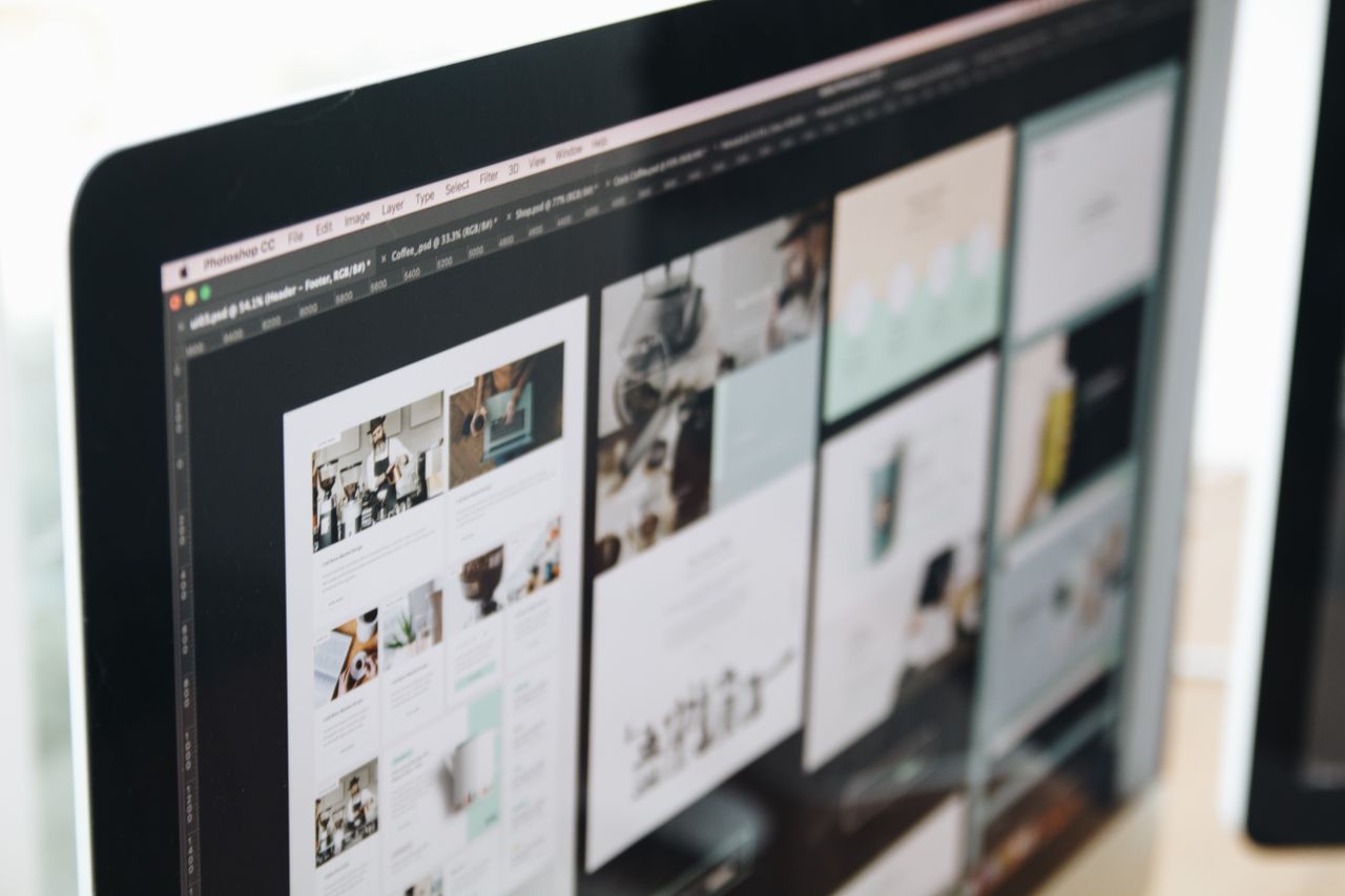 A modern computer display showing web design work, featuring creative visuals in a workspace.